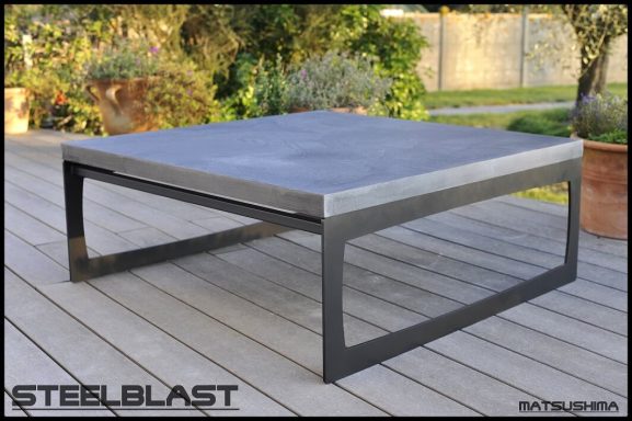Table basse en béton ciré pied métal acier avec un design moderne .